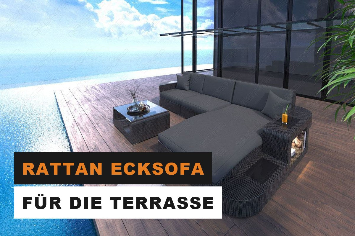 Graues Rattan Ecksofa in L-Form mit hellen Auflagen auf einer Terrasse