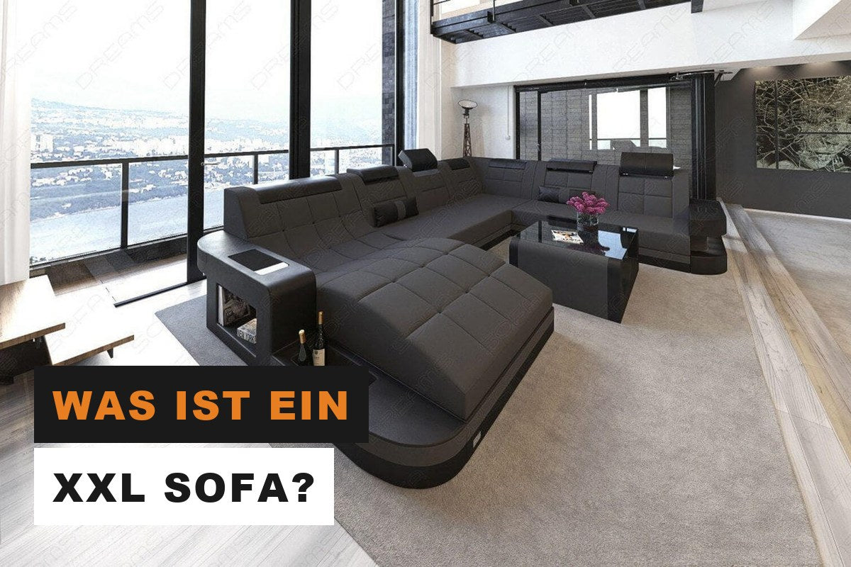 Dunkelgraue XXL Stoff-Wohnlandschaft in einem großen, hellen Wohnzimmer